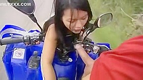 Thailandaise sportive baise sur un quad qui roule